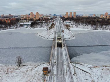 Aerial view beautiful urban landscape railway bridge over freezing river from drone