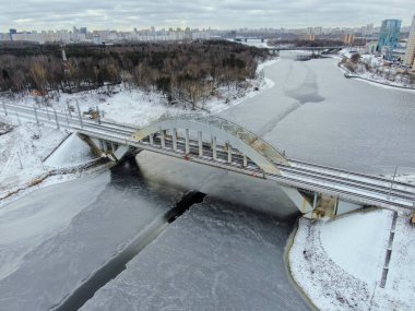 Aerial view beautiful urban landscape railway bridge over freezing river from drone