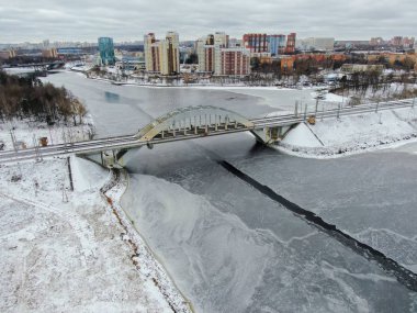 Aerial view beautiful urban landscape railway bridge over freezing river from drone