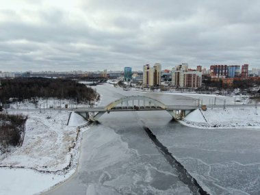 Aerial view beautiful urban landscape railway bridge over freezing river from drone