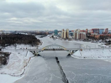 Aerial view beautiful urban landscape railway bridge over freezing river from drone