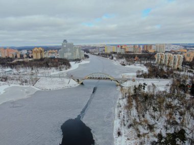 Aerial view beautiful urban landscape railway bridge over freezing river from drone