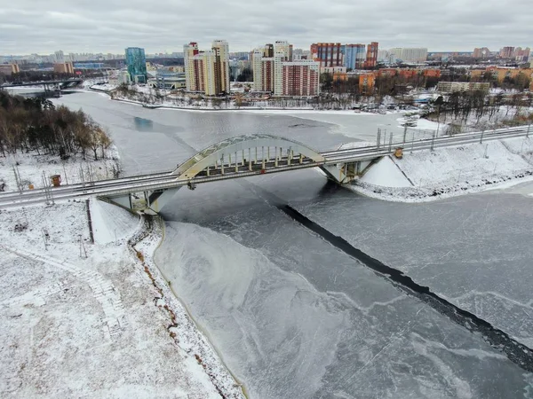 Aerial view beautiful urban landscape railway bridge over freezing river from drone