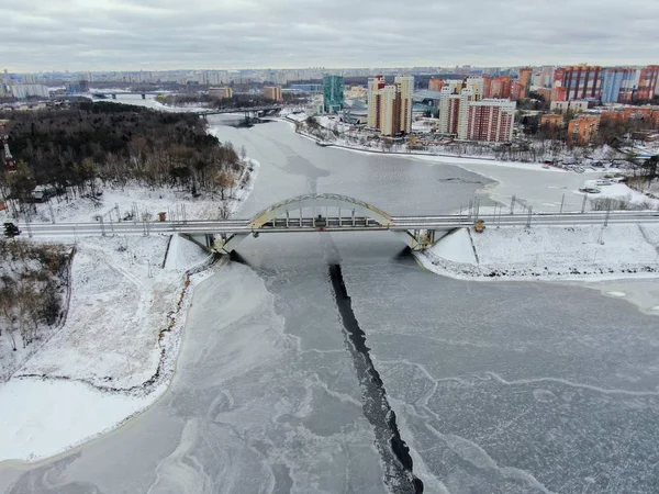 Aerial view beautiful urban landscape railway bridge over freezing river from drone