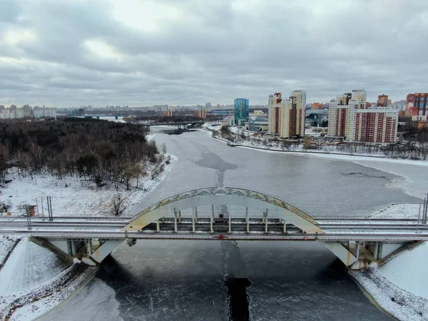 Aerial view beautiful urban landscape railway bridge over freezing river from drone