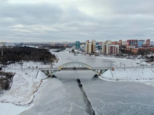 Aerial view beautiful urban landscape railway bridge over freezing river from drone