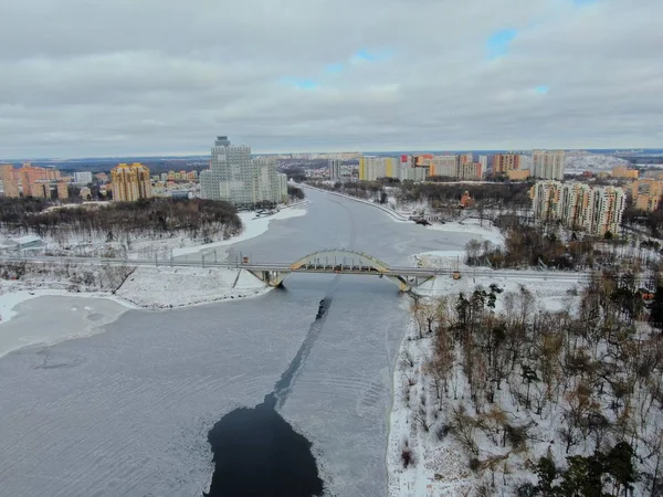Aerial view beautiful urban landscape railway bridge over freezing river from drone