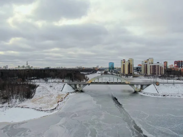 Aerial view beautiful urban landscape railway bridge over freezing river from drone