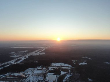 Yükselen güneşin ışınlarında hava manzaralı kış ormanı. Altın Kış Şafağı. İHA 'daki resim.