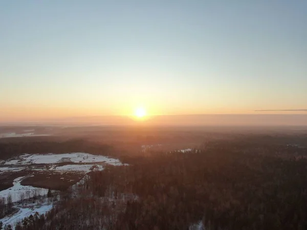 stock image Aerial view winter forest in the rays of the rising sun. Golden winter Dawn. The picture from the drone