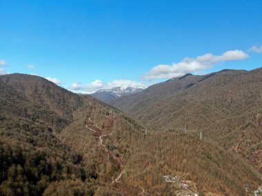 Güneşli bir günde insansız hava aracından gelen hava manzarası dağ manzarasının güzel bir manzarası. Mavi gökyüzünün ortasında ilkbahar dağları.