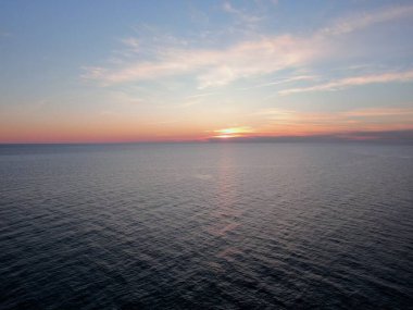 Deniz kıyısında hava manzaralı güzel bir şafak. Sabah güneşinin ışınlarıyla deniz sahilinin yüksekliğinden panoramik manzara