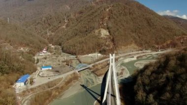 Hava manzaralı açık bir günde, bir dağ geçidinde uzanan güzel bir araba köprüsü. İnsansız hava aracından dağ manzarasının güzel manzarası