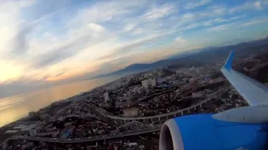 Zaman ayarlı kalkış uçağı büyük şehrin merkezindeki havaalanında. Uçak penceresinden denize ve dağlara giden yolcunun görüntüsü