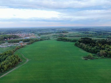 Yeşil alanın yüksekliğinden ormanın arka planına kadar uzanan güzel panoramik manzara. İnsansız hava aracından güzel bir görüntü.