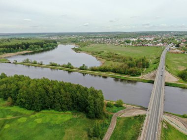 Nehrin üzerindeki köprünün yüksekliğinden güzel panoramik manzara. Kargo gemisinin yola çıktığı nehrin üzerindeki köprüde trafik vardı. İHA 'daki resim.