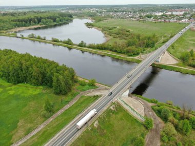 Nehrin üzerindeki köprünün yüksekliğinden güzel panoramik manzara. Kargo gemisinin yola çıktığı nehrin üzerindeki köprüde trafik vardı. İHA 'daki resim.