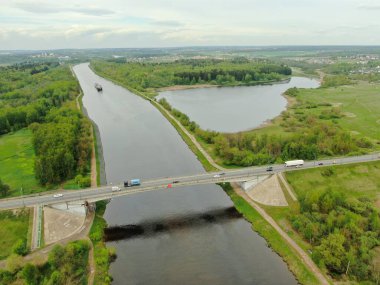 Nehrin üzerindeki köprünün yüksekliğinden güzel panoramik manzara. Kargo gemisinin yola çıktığı nehrin üzerindeki köprüde trafik vardı. İHA 'daki resim.