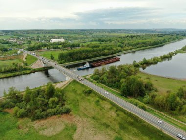 Nehrin üzerindeki köprünün yüksekliğinden güzel panoramik manzara. Kargo gemisinin yola çıktığı nehrin üzerindeki köprüde trafik vardı. İHA 'daki resim.