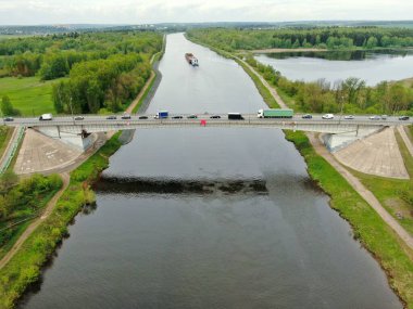 Nehrin üzerindeki köprünün yüksekliğinden güzel panoramik manzara. Kargo gemisinin yola çıktığı nehrin üzerindeki köprüde trafik vardı. İHA 'daki resim.