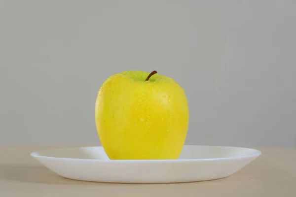 Gelber Apfel mit Wassertropfen — Stockfoto