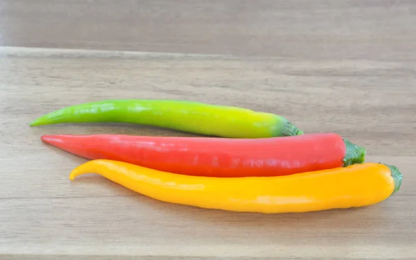 Three multicolored chilli peppers — Stock Photo, Image