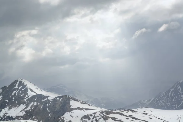 Işık huzmeleri bulutların arasından dağların üzerinden 