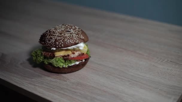 Hamburger Tient Sur Une Table Avec Une Texture Bois — Video