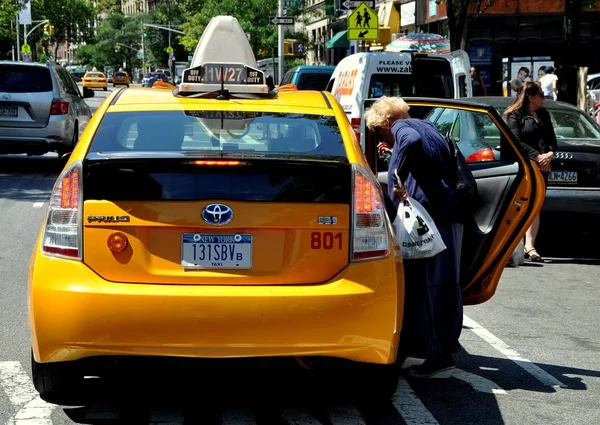 Нью-Йорк: W9man Entering a Taxi — стоковое фото