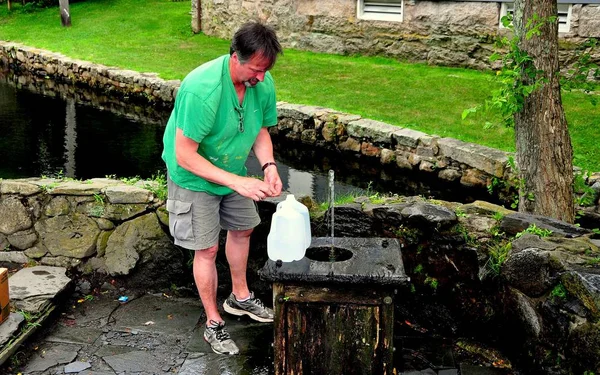 Sandwich, MA: Man at Well Filling Bottle — Stock Photo, Image