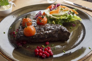 whale steak with tomatoes and currant at the lofoten islands in Norway clipart