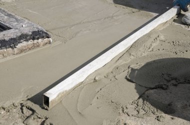 bir çatı yenileme için bir bina yerinde çimento atar işçi