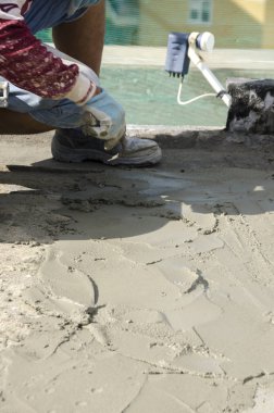 bir çatı yenileme için bir bina yerinde çimento atar işçi