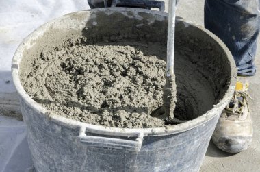 bir çatı yenileme için bir bina yerinde çimento atar işçi