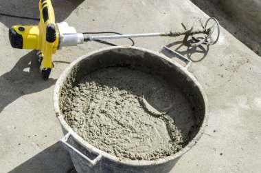 bir çatı yenileme için bir bina yerinde çimento atar işçi
