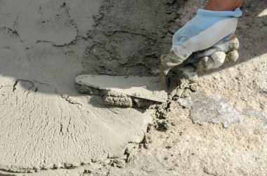 bir çatı yenileme için bir bina yerinde çimento atar işçi