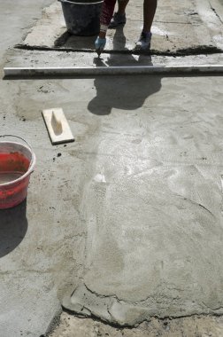 bir çatı yenileme için bir bina yerinde çimento atar işçi