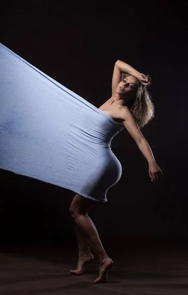 Красивая молодая девушка танцует с голубой тканью — стоковое фото