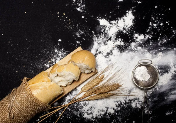 Pane e farina sul tavolo nero — Foto Stock