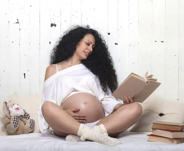 Счастливая беременная женщина в постели — стоковое фото