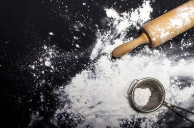 Metal süzgeç ve oklava ile un dökülüp
