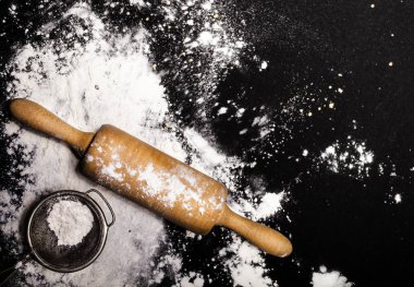 Metal süzgeç ve oklava ile un dökülüp
