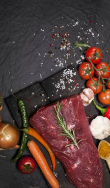 Bir kesme tahtası biberiye ve baharatlar ile ham sığır eti biftek.