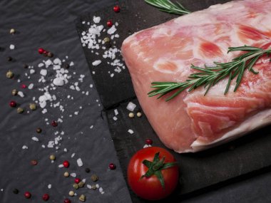 Biberiye, sebze ve baharatlar ile kesme tahtası üzerinde çiğ domuz eti.