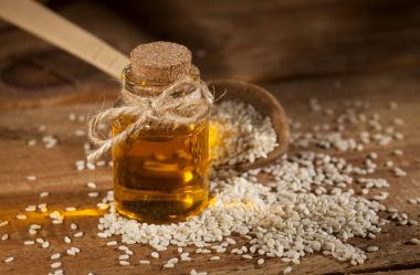 cam şişe ve bir tahta kaşıkla tohumlar taze susam yağı