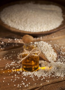 Cam şişe ve tohum ahşap tabak ve kaşık taze susam yağı