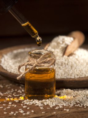 Cam şişe ve tohum ahşap tabak ve kaşık taze susam yağı