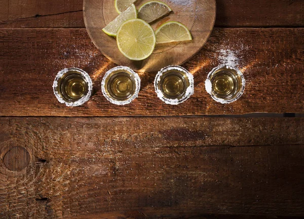 Tiros de tequila sobre fondo de madera — Foto de Stock