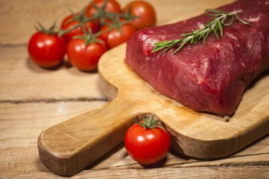 Bir kesme tahtası biberiye ve baharatlar ile ham sığır eti biftek.