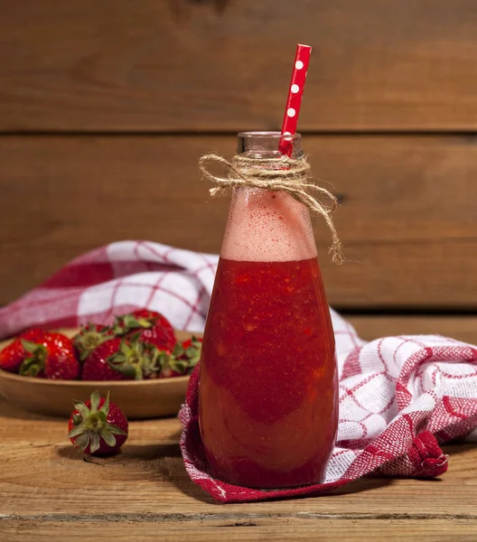 Batido de fresa o batido en botella sobre fondo rústico de madera . — Foto de Stock